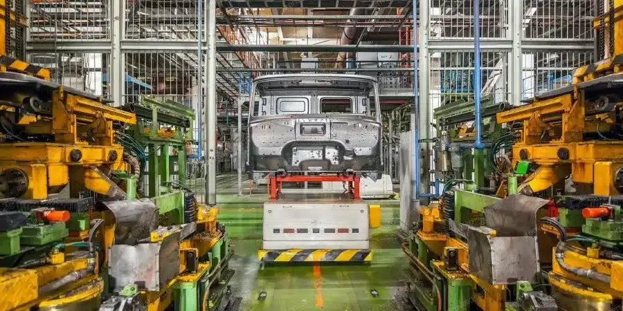 A view of a factory hall featuring heavy machinery on both sides, with additional machinery visible at the far end of the aisle, symbolising the activities in South Africa's manufacturing sector.