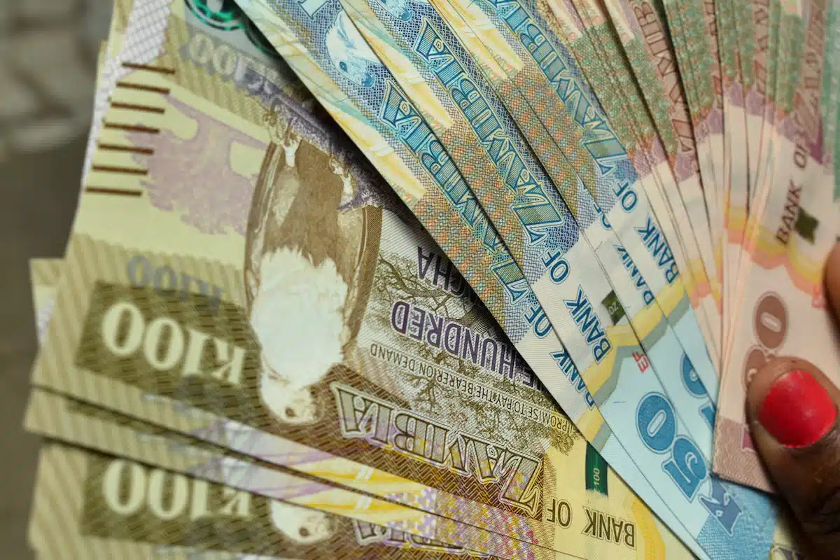 A woman displays a selection of Kwacha notes, the national currency and money used in Zambia.