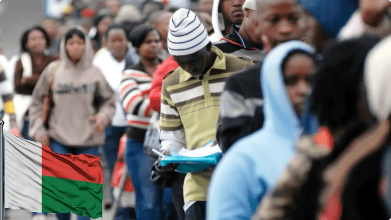 Job seekers standing in a line. A Madagascar flag superimposed on the image, symbolising unemployment in the country
