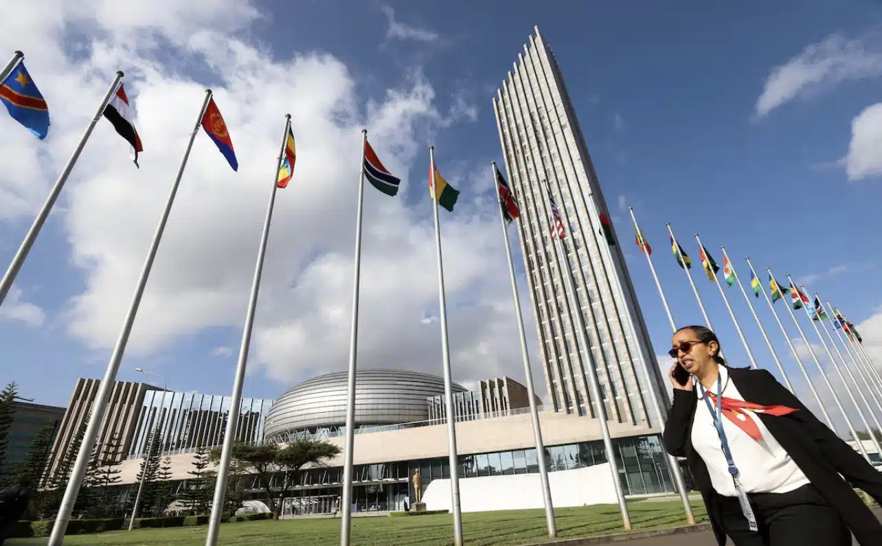 A delegate walks past African Union (AU) member states national flags during the opening of the 37th Ordinary Session of the Assembly of the African Union at the African Union Headquarters, in Addis Ababa, Ethiopia