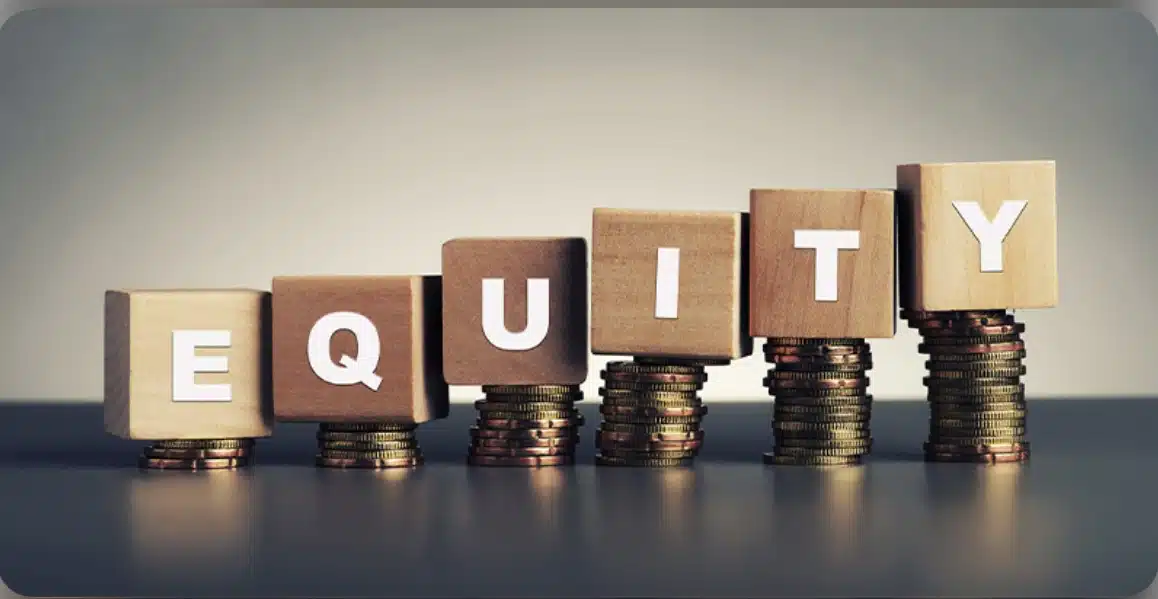 Wooden cubes that spell EQUITY sitting on ascending stacks of coins