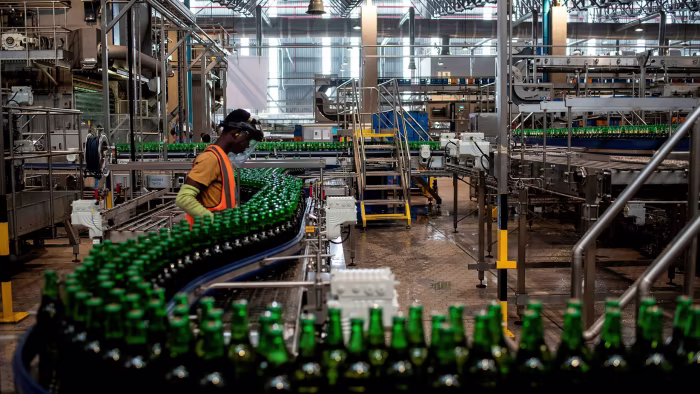 An image showing a man monitoring the production of bottle drinks