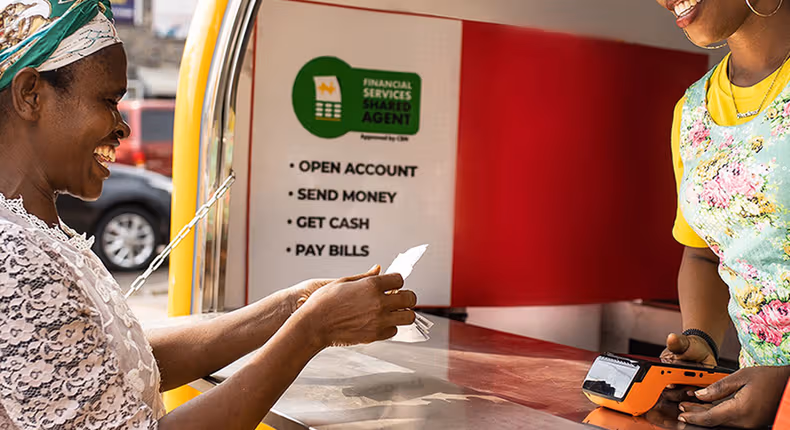 Image of a Kenyan woman performing a mobile money transaction.