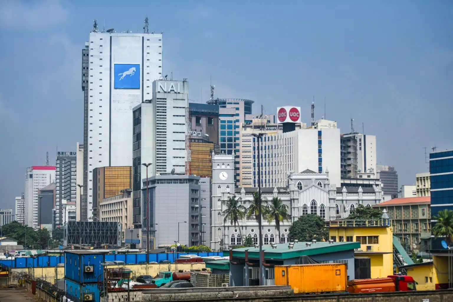 A cityscape of Lagos, Nigeria, showing modern high-rise office buildings with company logos, including a white tower featuring the Union bank signage