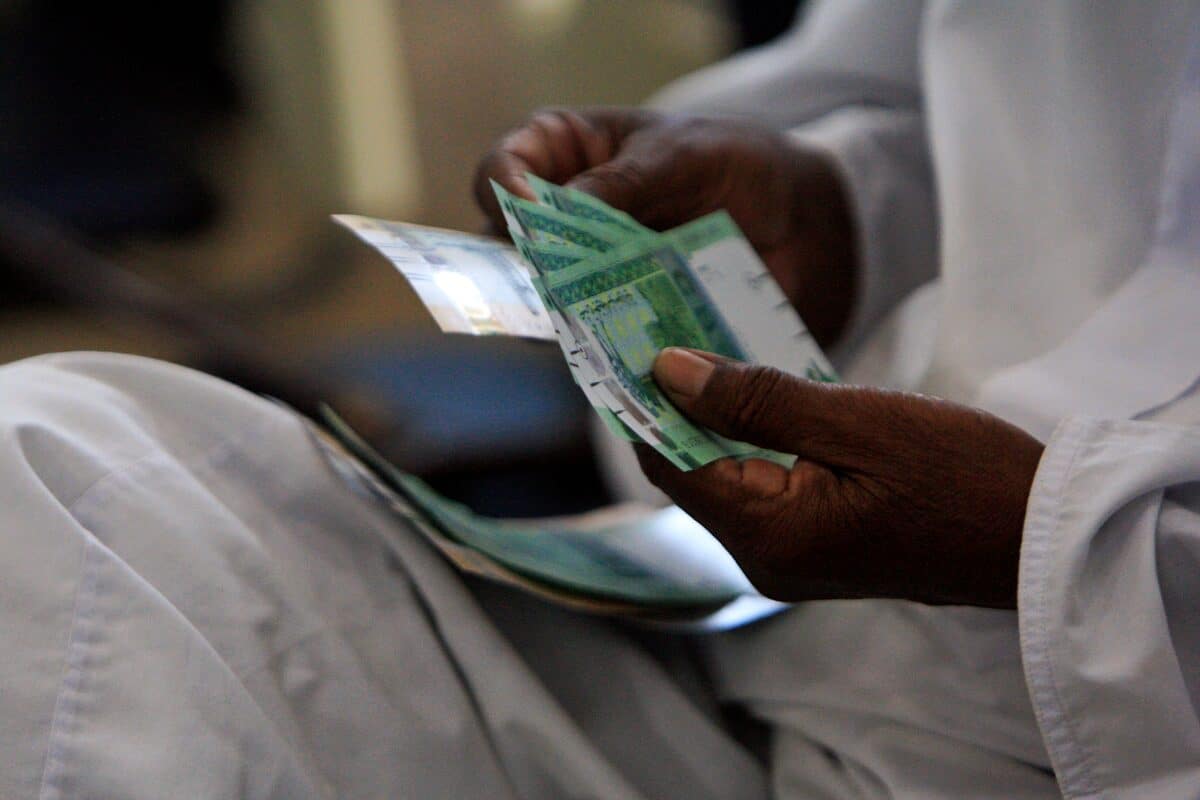 A man counts notes after receiving the new Sudanese currency at a central bank branch in Khartoum